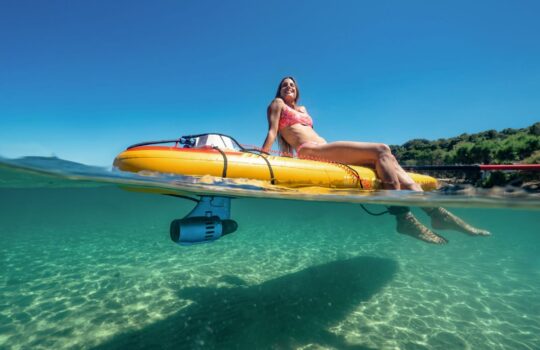 Žena sjedi na žutoj SUP dasci u bistrom moru